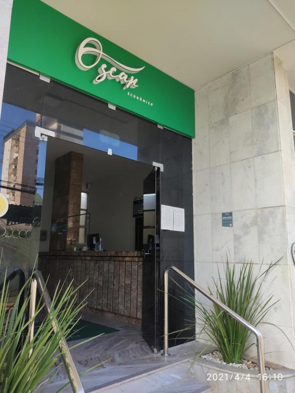 a store front with a green sign on a building at Hotel Oscar Econômico Montes Claros in Montes Claros