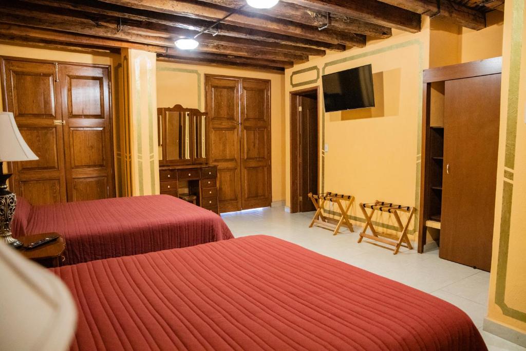 Cette chambre comprend 2 lits et une télévision à écran plat. dans l'établissement Cuartel 1914 - Hotel Boutique, à Zacatecas
