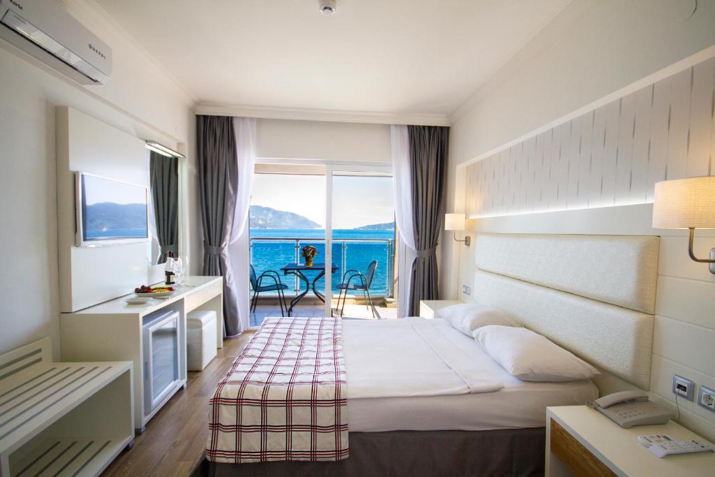 a hotel room with a bed and a view of the ocean at Yunus Hotel in Marmaris