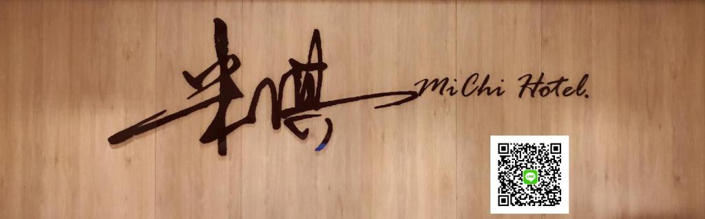 a sign on a wooden wall with writing on it at Michi Hotel - Luodong in Luodong