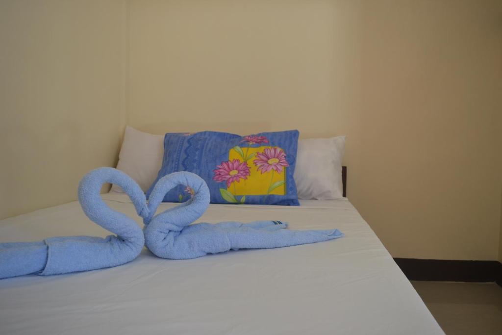two towel swans sitting on top of a bed at Amor En Beach House in Oslob