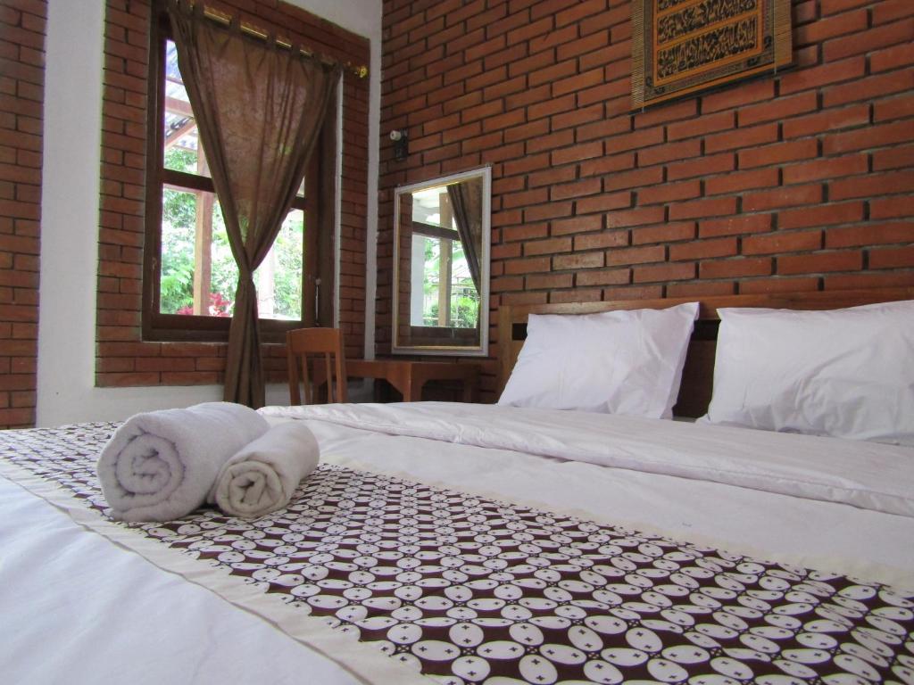 a bedroom with two beds with towels on them at Penginapan Udin Syariah Bukit Rhema in Magelang