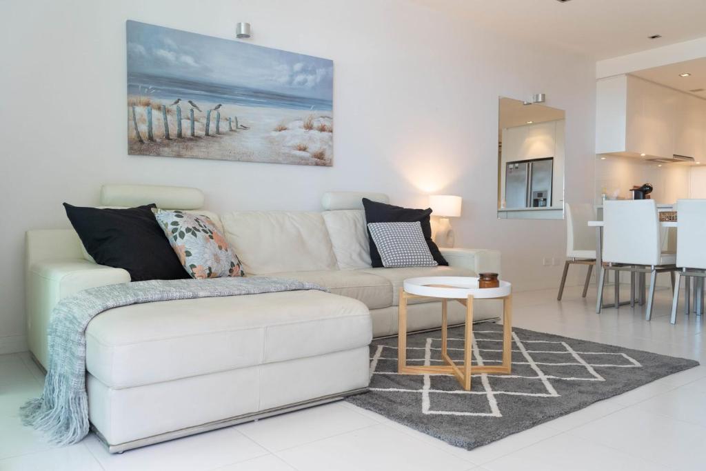 a living room with a white couch and a table at Luxury beachfront apartment at The Breeze - Free Wifi in Victor Harbor