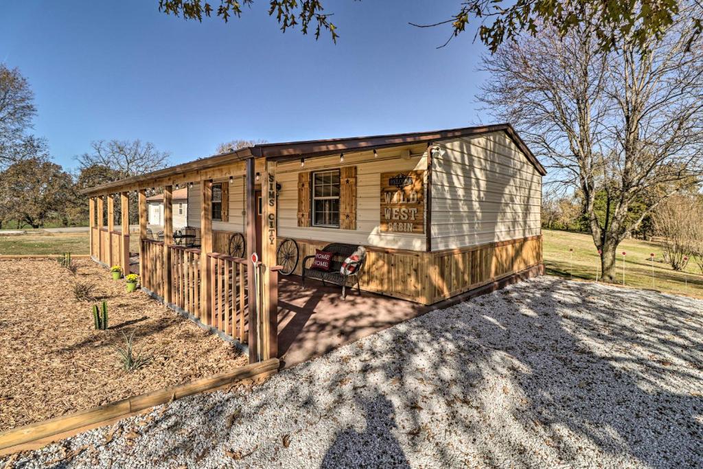 a tiny house is sitting in a field at Rustic Sims City Studio Cabin with Home Theater! in Harrison