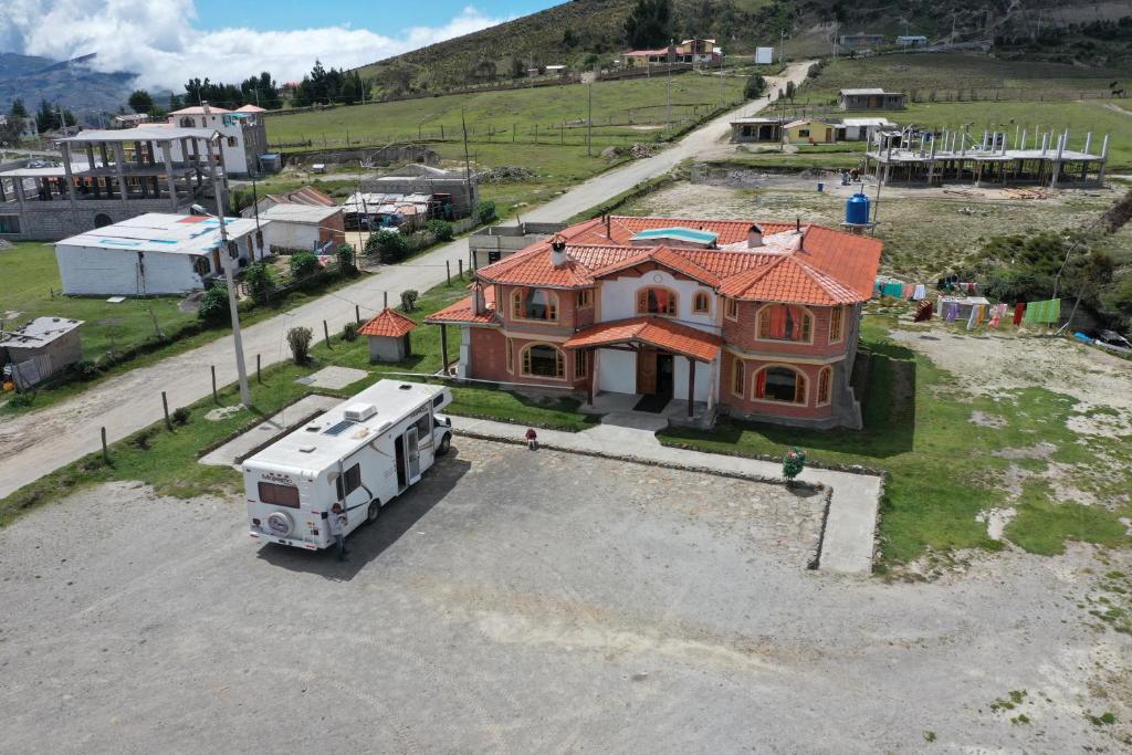 een luchtfoto van een huis met een vrachtwagen ervoor bij Runa Wasi Quilotoa in Quilotoa