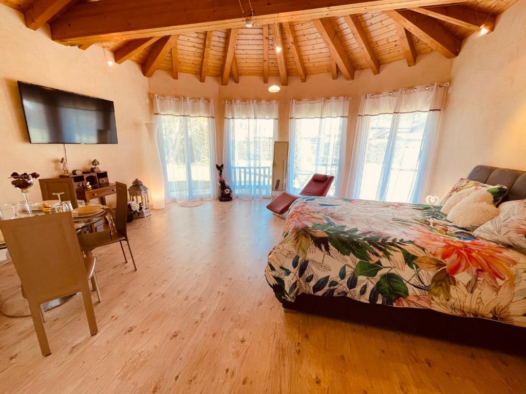 een slaapkamer met een bed, een eetkamer en een tafel bij Suite hôtelière au cœur du Valais in Saxon
