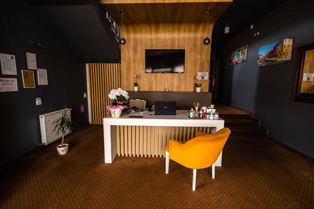 特爾古穆列什的住宿－Pensiunea Flora，办公室,带桌子和黄椅