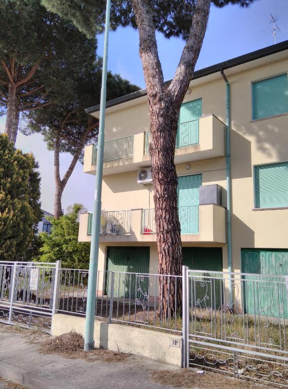 a tree in front of a building at Mare Pineta 2 in Lido di Volano