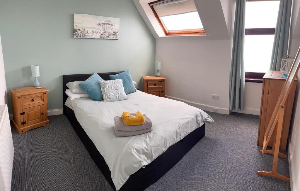 een slaapkamer met een groot bed met blauwe kussens bij Skerry View - Overlooking the Moray Firth - close to Beaches, Harbour, Shops and Restaurants in Lossiemouth