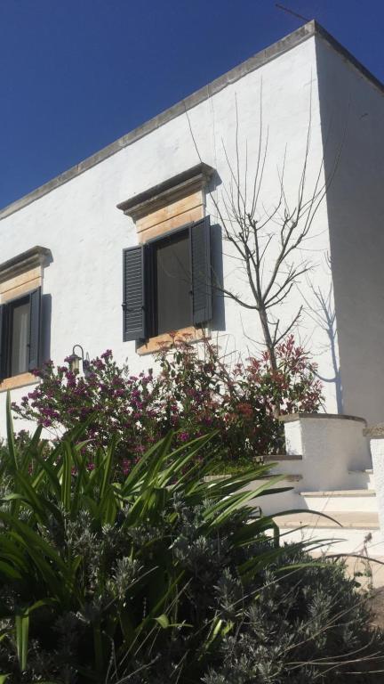 een wit gebouw met een raam en een aantal planten bij Casina Fumarola in Ostuni