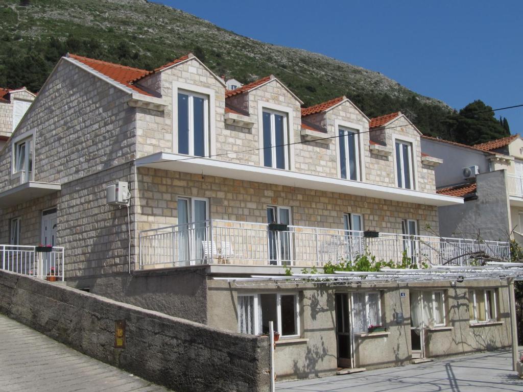 un bâtiment avec une colline en arrière-plan dans l'établissement Apartments Gera, à Dubrovnik