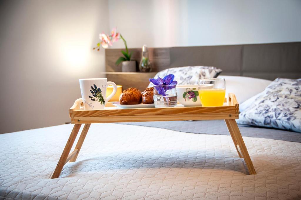 a tray of food and drinks on a table on a bed at Apartment & Rooms Graciela in Rovinj