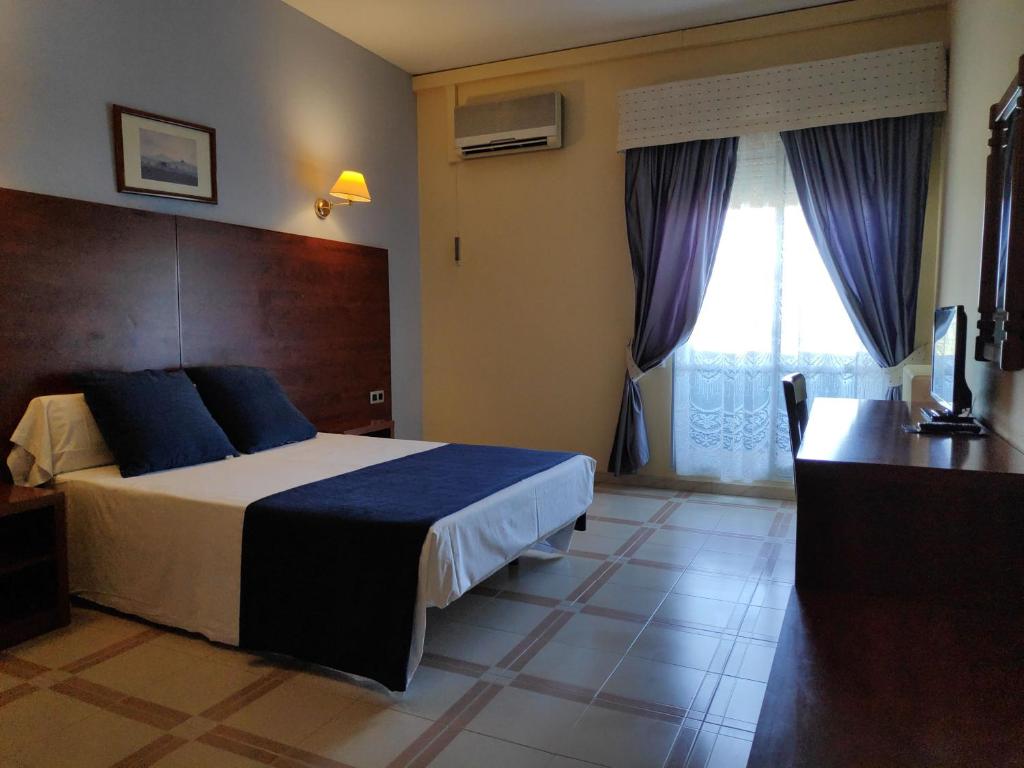 Un dormitorio con una cama y un escritorio y una ventana. en Hotel Perú by Bossh Hotels, en Trujillo