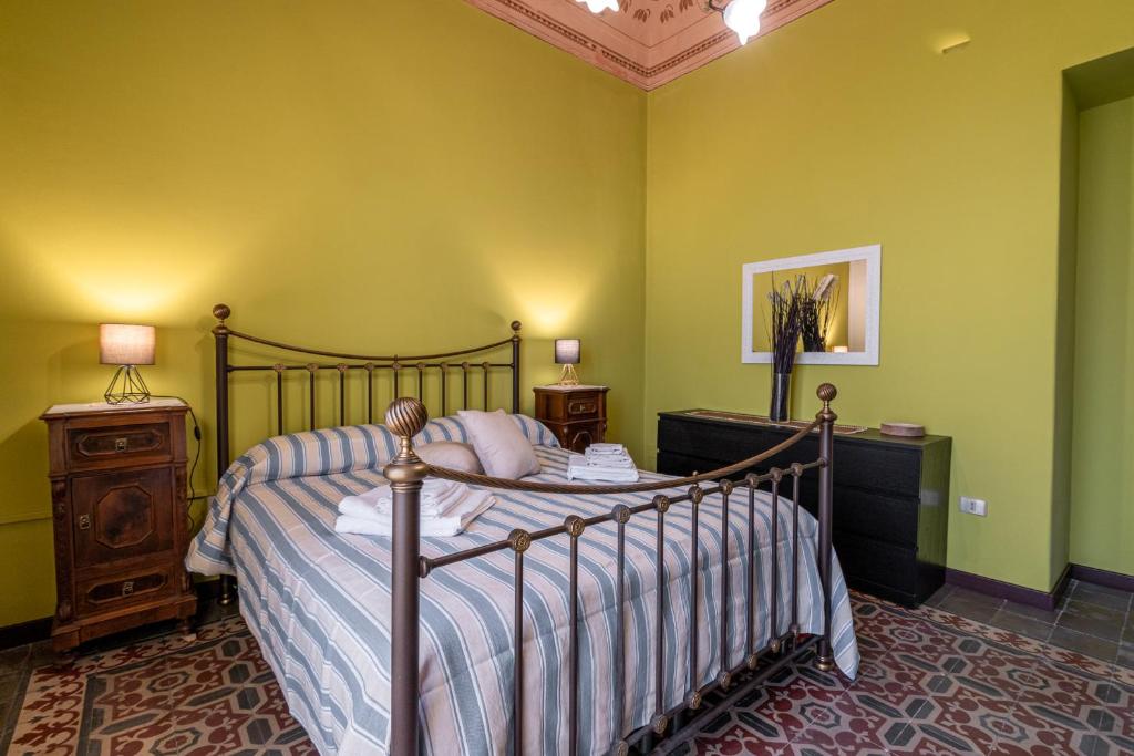 a bedroom with a bed and green walls at Fermata Jonia in Giarre