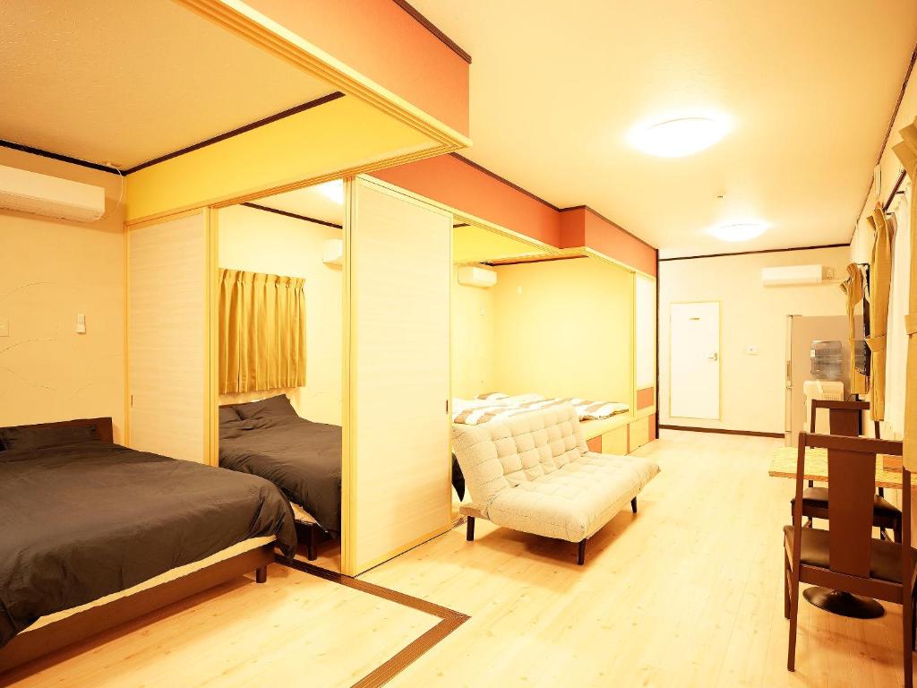 那霸的住宿－Mcity in Maejima，一间卧室配有一张床、一张沙发和一把椅子