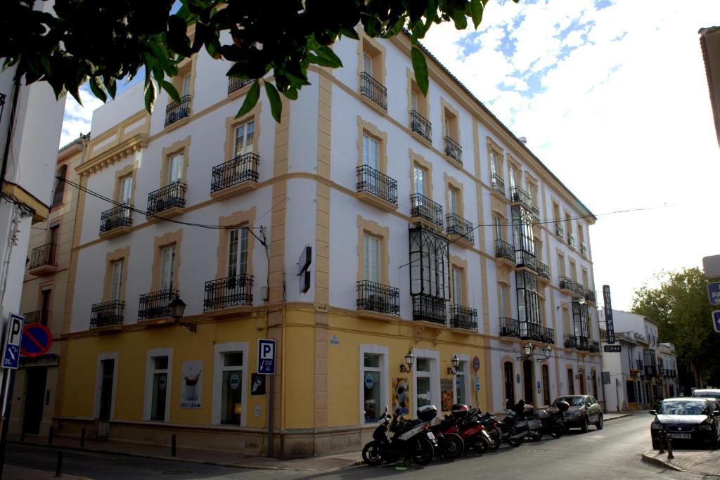 ein gelbes Gebäude, vor dem Motorräder geparkt sind in der Unterkunft Ronda Hotel Polo in Ronda