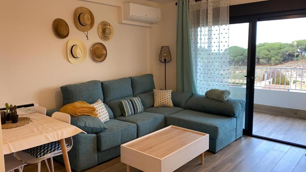 sala de estar con sofá azul y mesa en PINOMAR, en La Mata