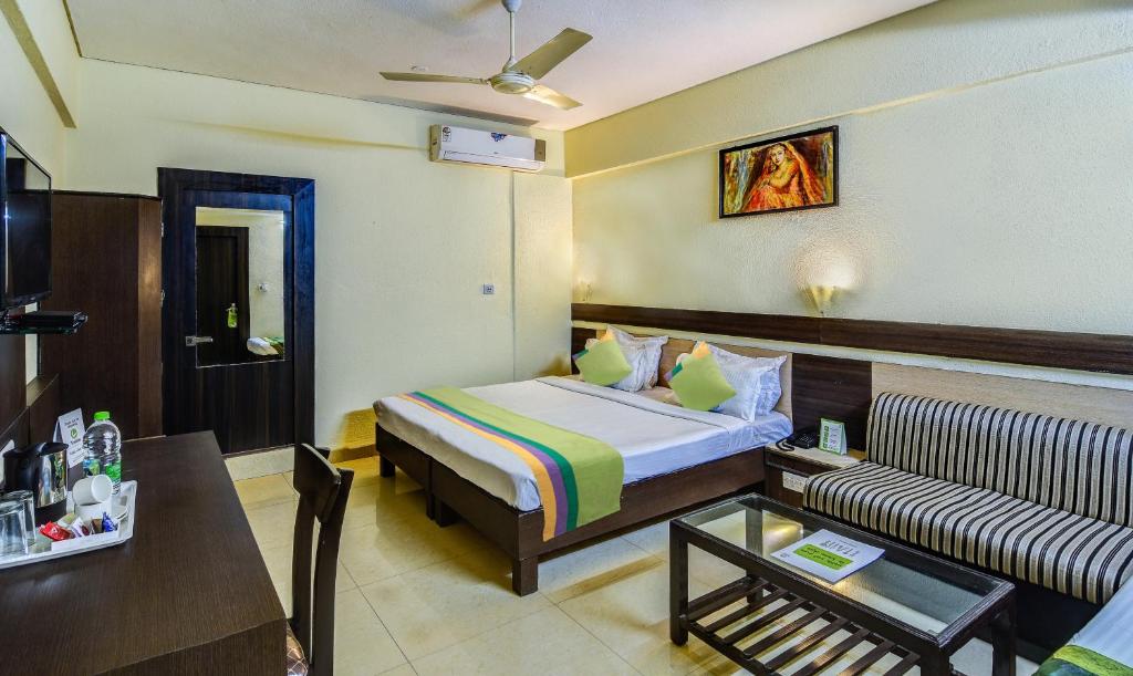 Habitación de hotel con cama y sofá en Treebo Trend The Shagun Peer Gate, en Bhopal