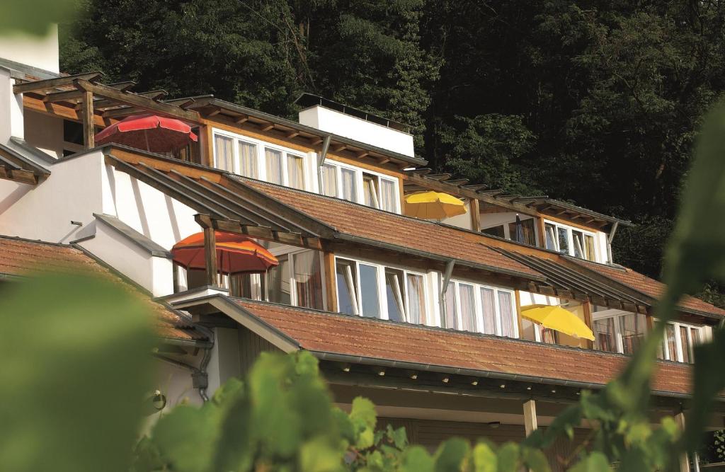 um edifício com guarda-chuvas coloridos em cima em Residence Haus Kaltersee em Caldaro