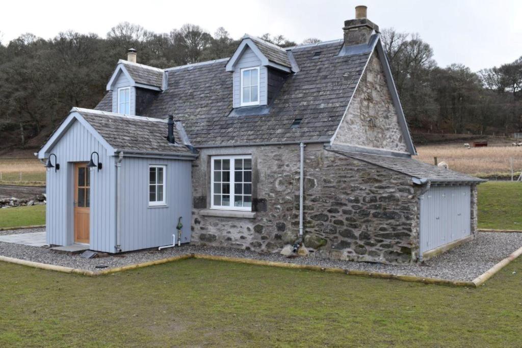 a small stone house with a gambrel roof at Osprey Cottage, Port o Tay in Pitlochry