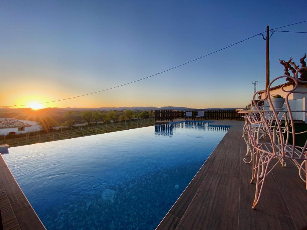 a large swimming pool with the sunset in the background at Bed & Breakfast Wine & Cooking Penedès in Pla del Panadés