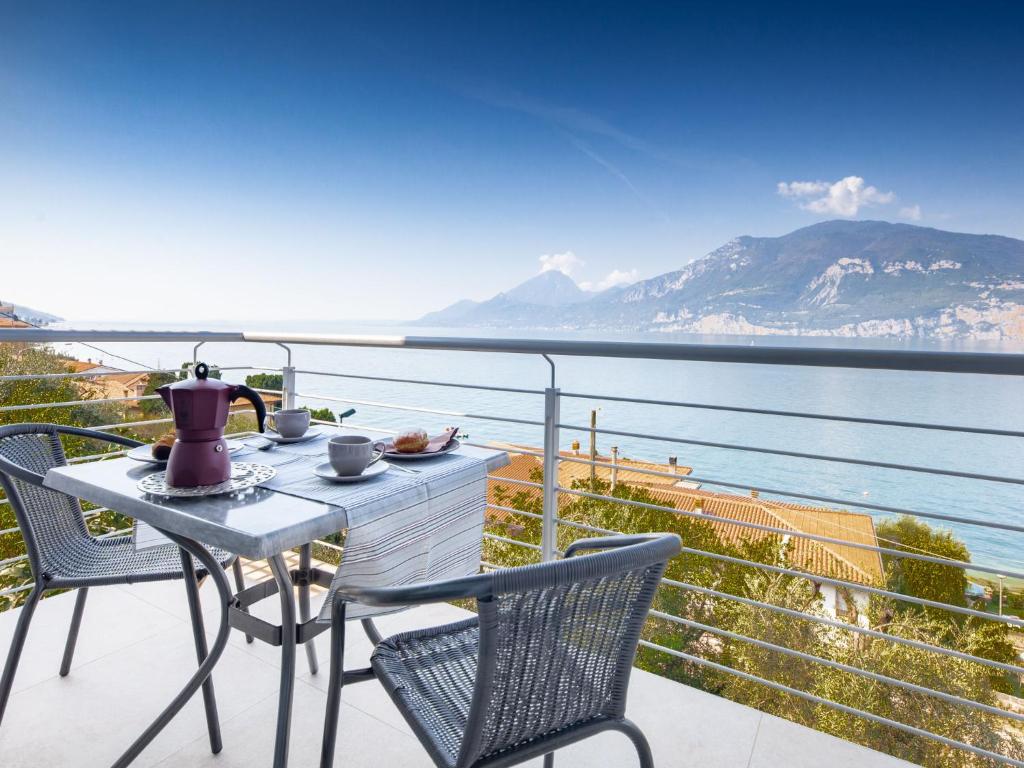 a table and chairs on a balcony with a view of the water at Apartment La Maison Blanche-2 by Interhome in Brenzone sul Garda