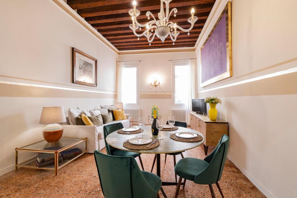 a living room with a table and chairs and a couch at CA' MALIPIERO in Venice