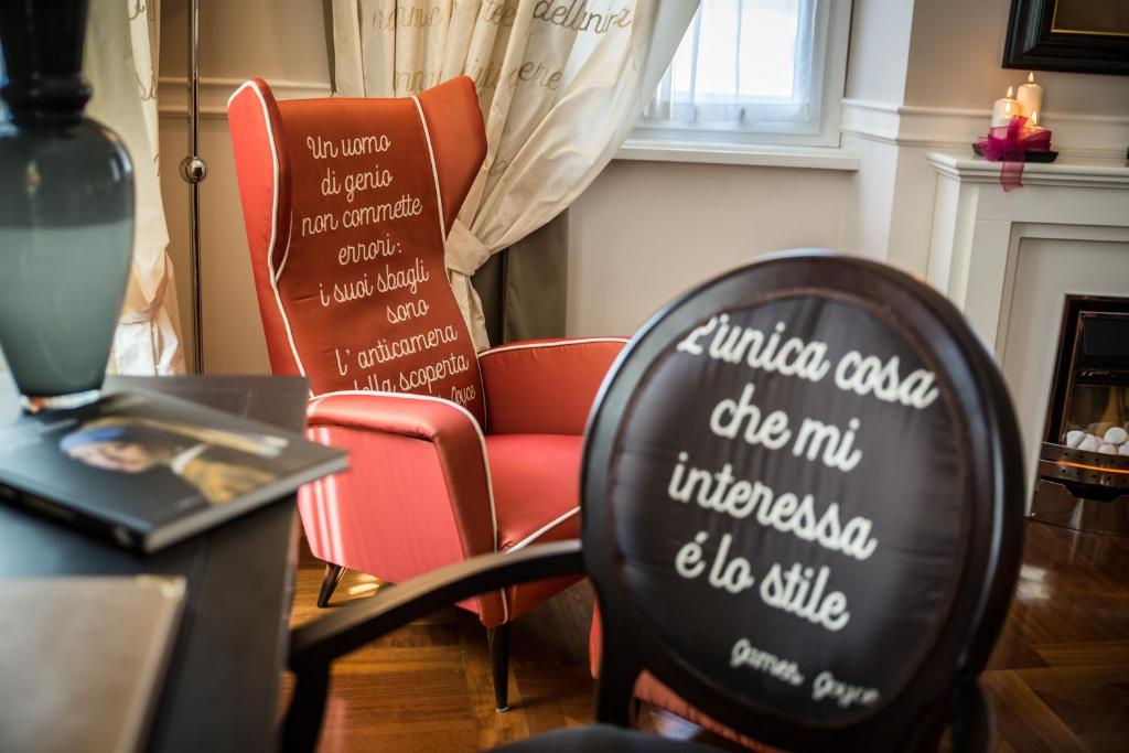 una habitación con una silla y una mesa con escritura. en Victoria Hotel Letterario en Trieste