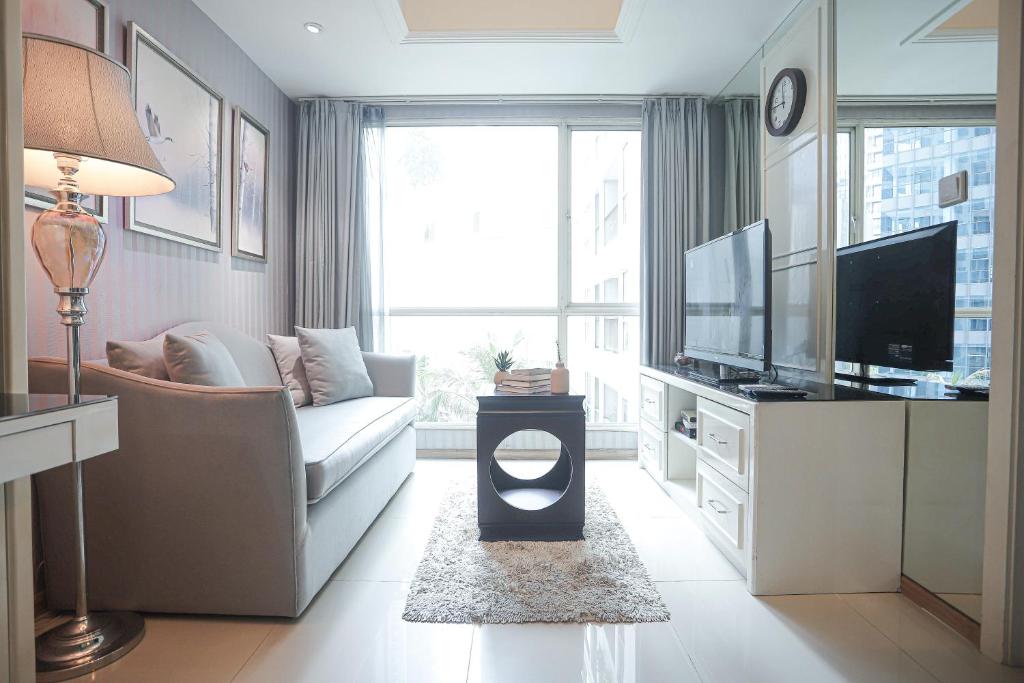 ein Wohnzimmer mit Couch und Fernseher in der Unterkunft Classica by Kozystay - Kuningan in Jakarta