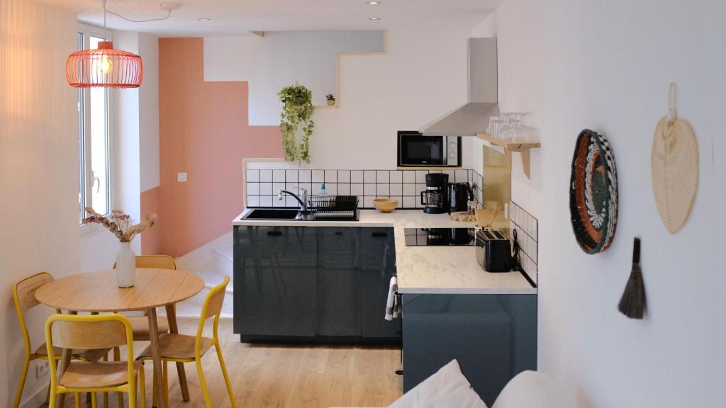 une cuisine avec un évier et une table avec des chaises dans l'établissement Palma rosa, à Cannes