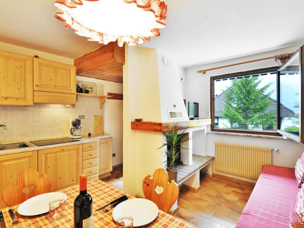cocina con mesa, sillas y ventana en Apartment Monti Pallidi by Interhome en Campitello di Fassa