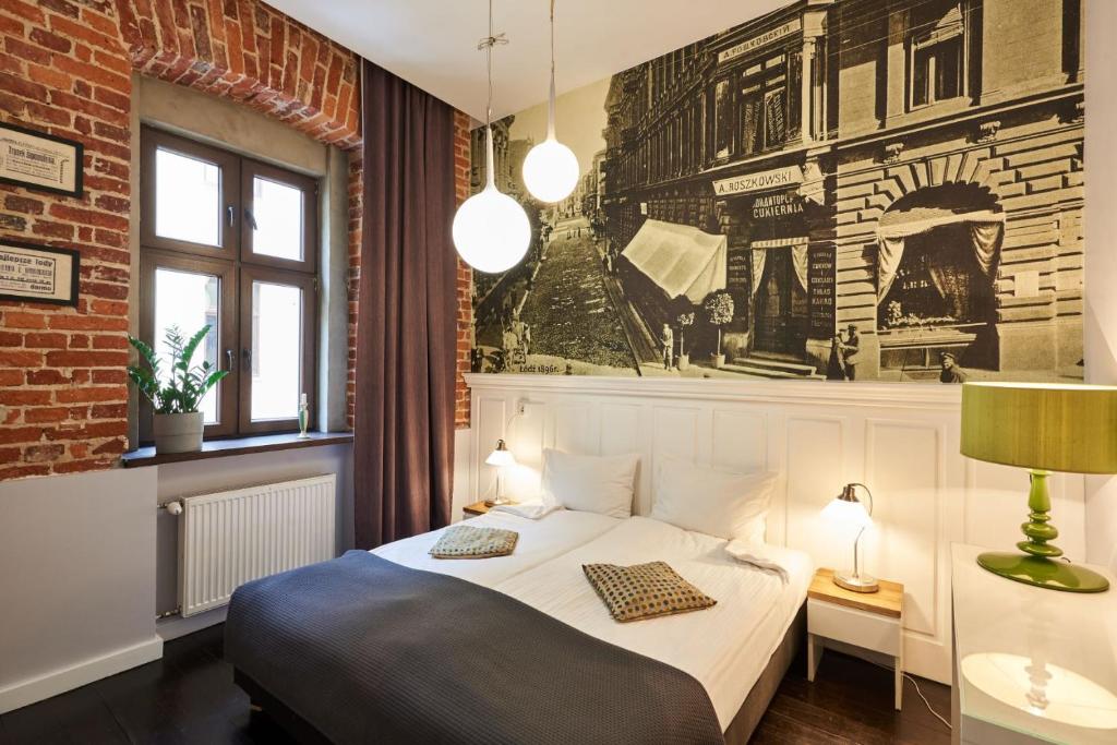 sypialnia z łóżkiem i ceglaną ścianą w obiekcie Apartament Patisserie by Good Time w Łodzi