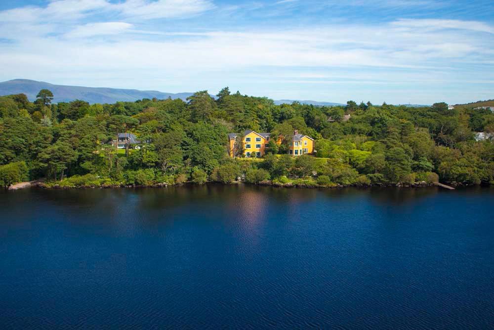 a house on an island in the middle of a lake at Carrig Country House & Restaurant in Killorglin