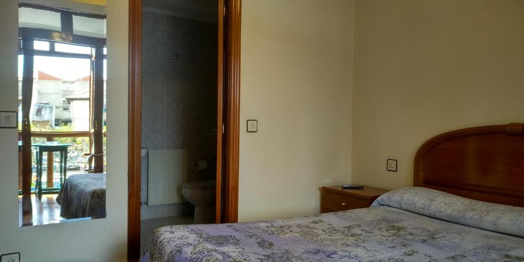 1 dormitorio con 1 cama y baño con ventana en HOSTAL SANCHO GARCIA en Espinosa de los Monteros