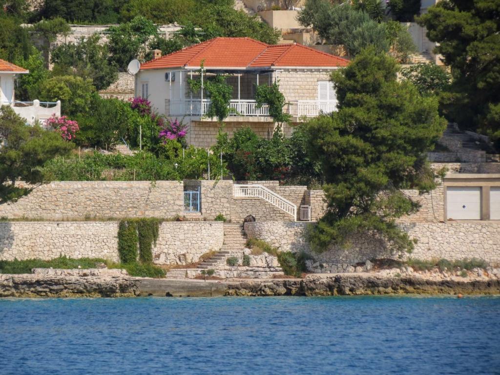 a house on a hill next to the water at Holiday Home Bernardi by Interhome in Lumbarda