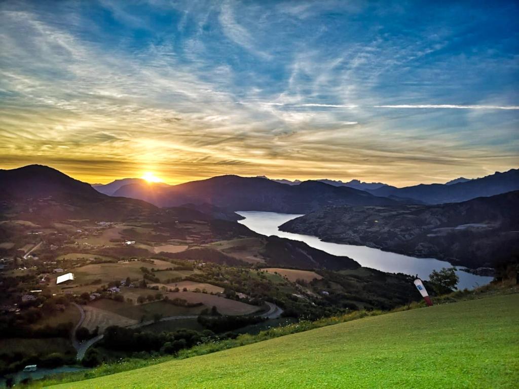 - un coucher de soleil sur une vallée avec un lac et des montagnes dans l'établissement L'Auberge, à Saint-Vincent-les-Forts