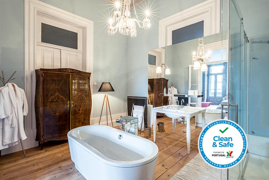 a large bathroom with a bath tub and a table at Charm Palace Porto in Porto