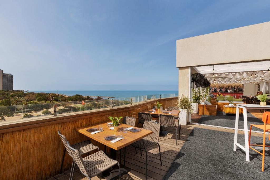 a patio area with chairs, tables, and umbrellas at Alexander Hotel in Tel Aviv