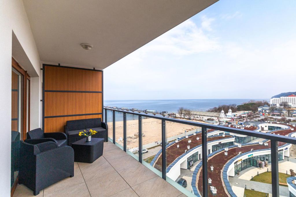 een balkon met stoelen en uitzicht op het strand bij Prima Playa in Międzyzdroje