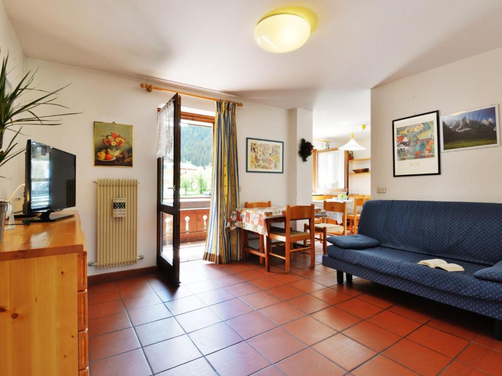 a living room with a blue couch and a table at Apartment Cesa Palua by Interhome in Alba di Canazei