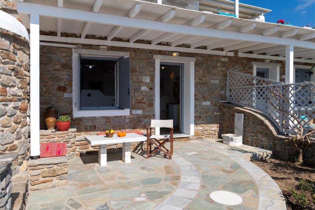 eine Terrasse mit einem weißen Tisch auf einer Steinterrasse in der Unterkunft Margarita Countryside Studios in Pounda