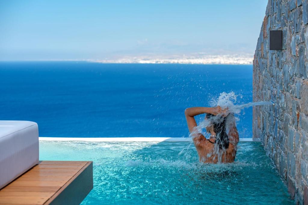 a woman in the water in a swimming pool at Malvezzino Luxury Villas in Palaiokastro