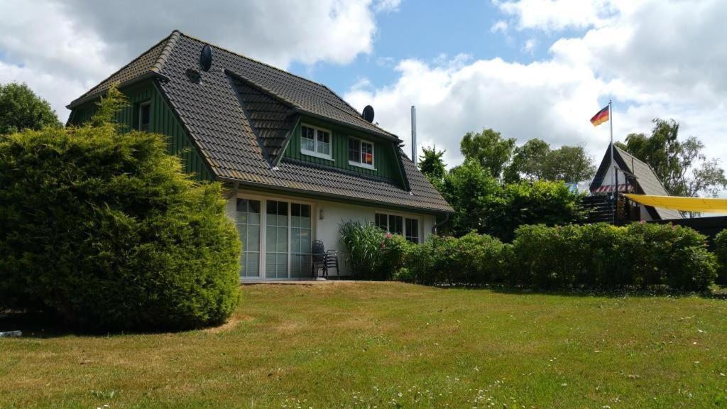uma casa verde com uma bandeira no quintal em Dorfstr_ OT Mueggenburg em Klein Kirr