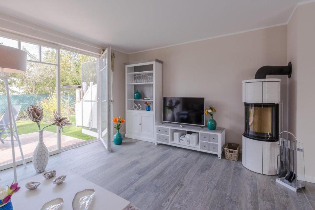 a living room with a tv and a large window at Birkmaase 1 a _Abendklang_ in Zingst