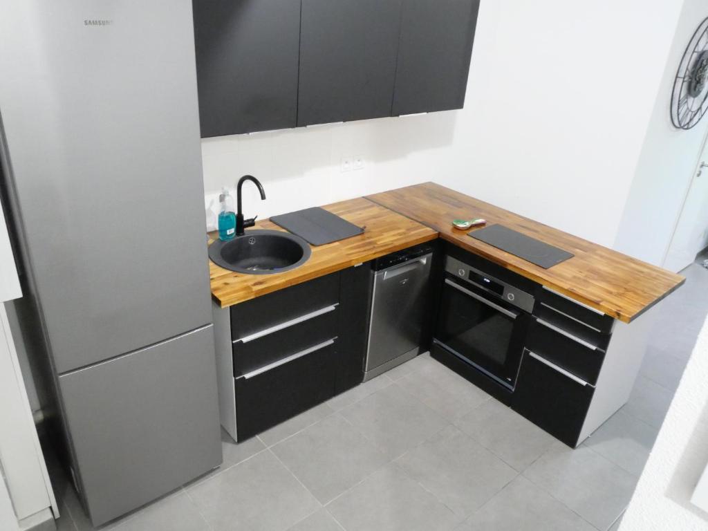 een kleine keuken met een wastafel en een aanrecht bij Appartement spacieux et moderne - Tout confort in Hendaye