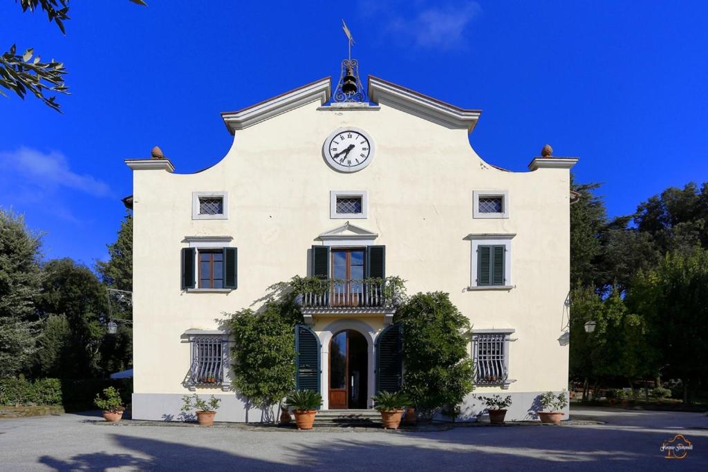 a large white building with a clock on it at VdP Luxury Tuscan Villa in San Baronto