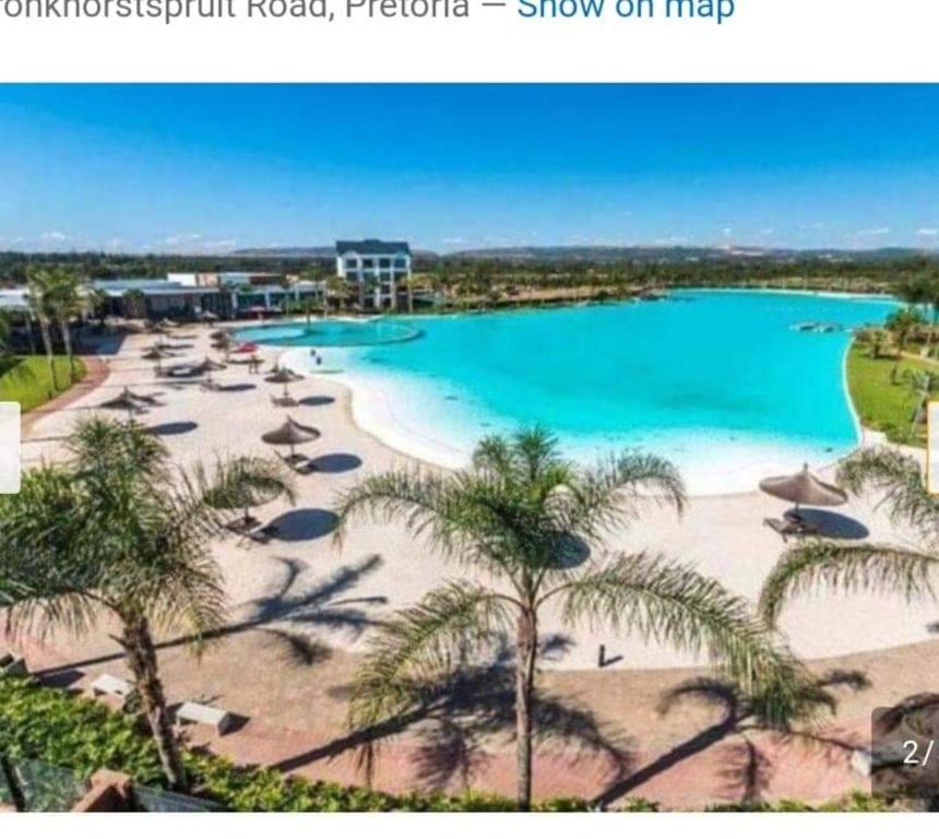 a view of a beach with palm trees and a pool at The blyde Pretoria unit 1244 in Pretoria