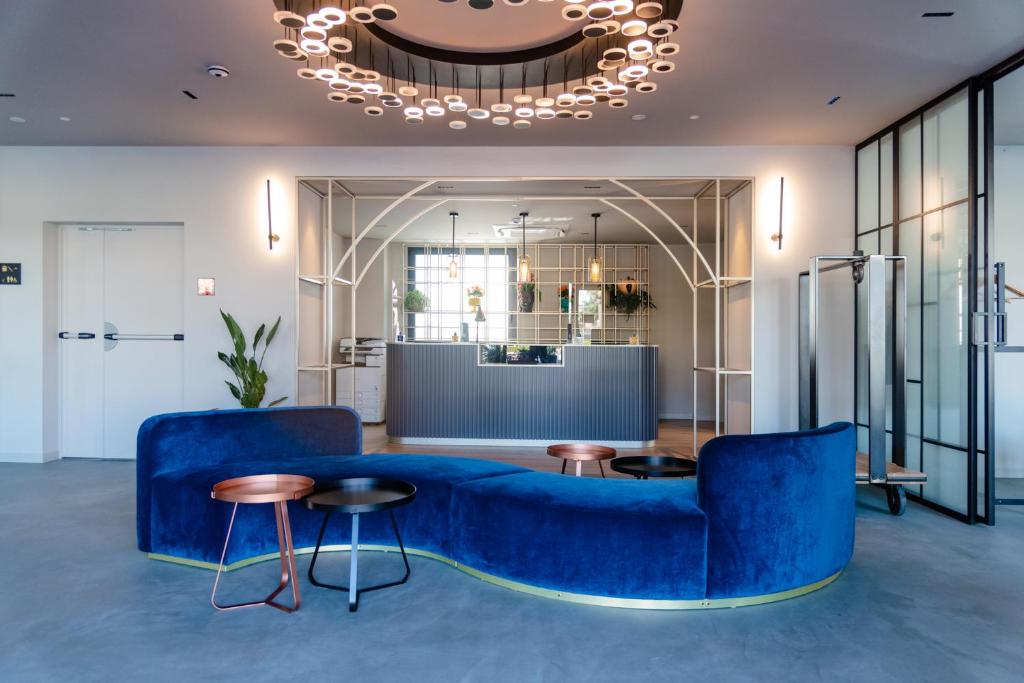 a living room with a blue couch and tables at Modica Boutique Hotel in Modica