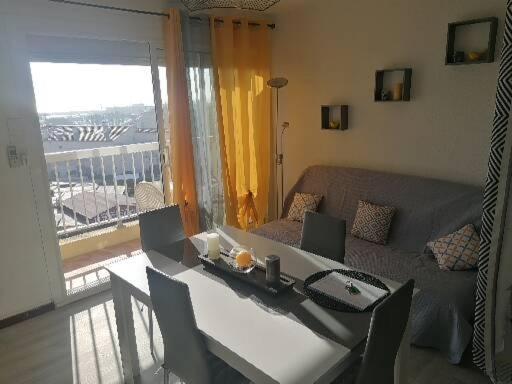 - un salon avec un canapé et une table avec des chaises dans l'établissement Appartement avec vue superbe sur le port, à Saint-Cyprien