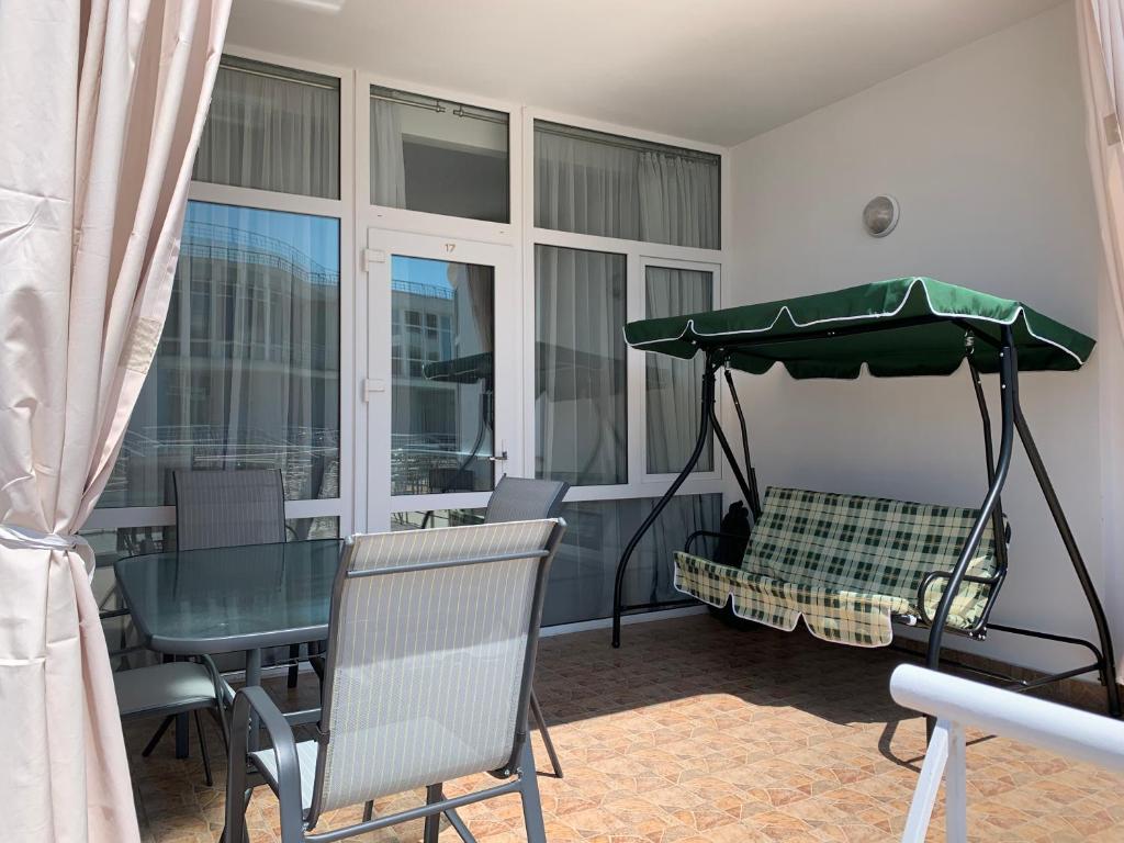 a dining room with a table and a green umbrella at Town-house Golden Bugaz in Karolino-Buhaz
